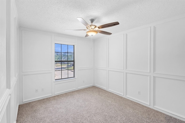 carpeted empty room featuring ceiling fan and a textured ceiling