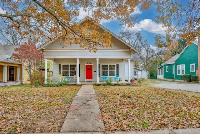 bungalow-style house with a porch and a front lawn