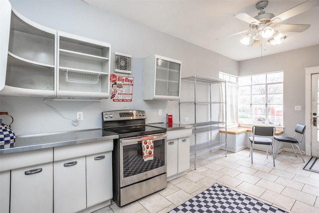 kitchen featuring light tile patterned floors, electric range, white cabinetry, and ceiling fan