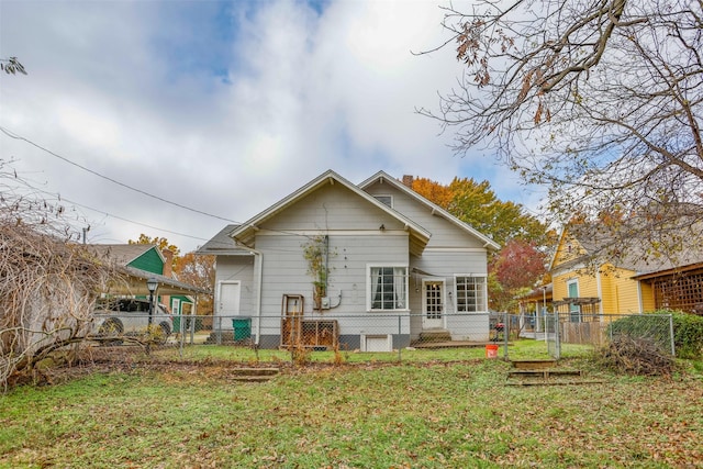 rear view of property featuring a lawn