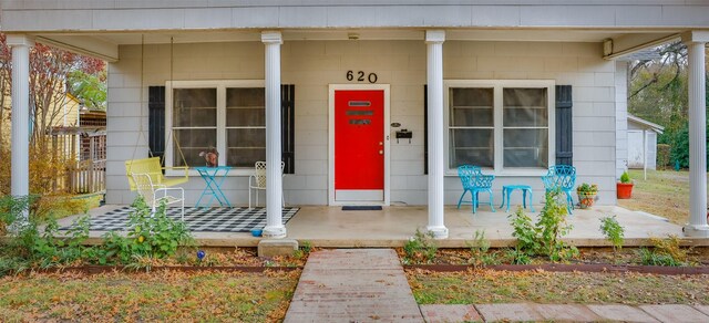 view of exterior entry featuring covered porch