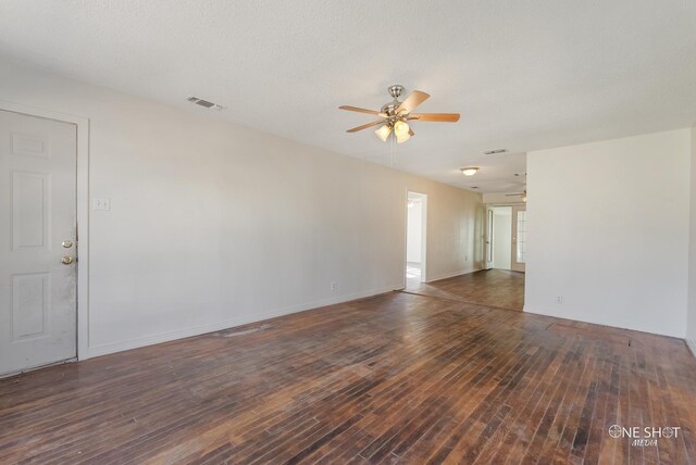 empty room with dark hardwood / wood-style floors, ceiling fan, and a textured ceiling