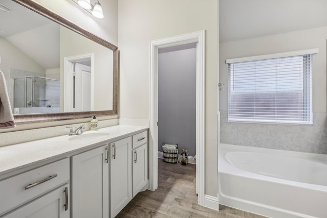 bathroom with hardwood / wood-style flooring, vanity, lofted ceiling, and plus walk in shower