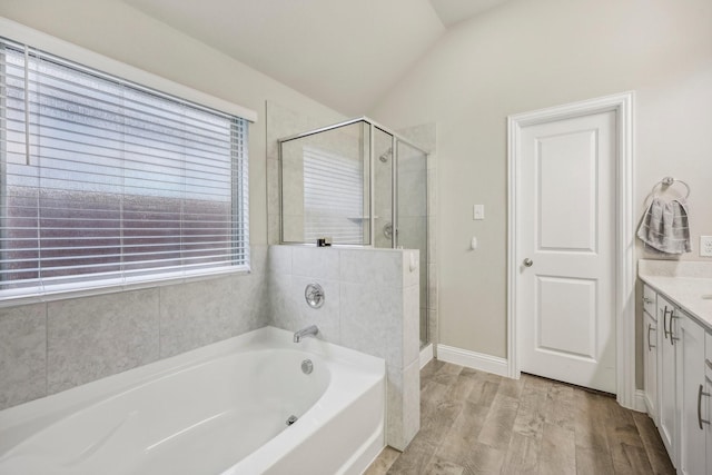 bathroom with plus walk in shower, vanity, wood-type flooring, and vaulted ceiling