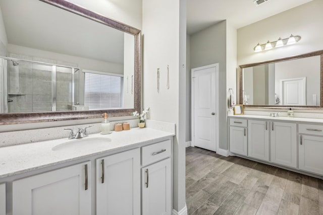 bathroom with hardwood / wood-style floors, vanity, and walk in shower