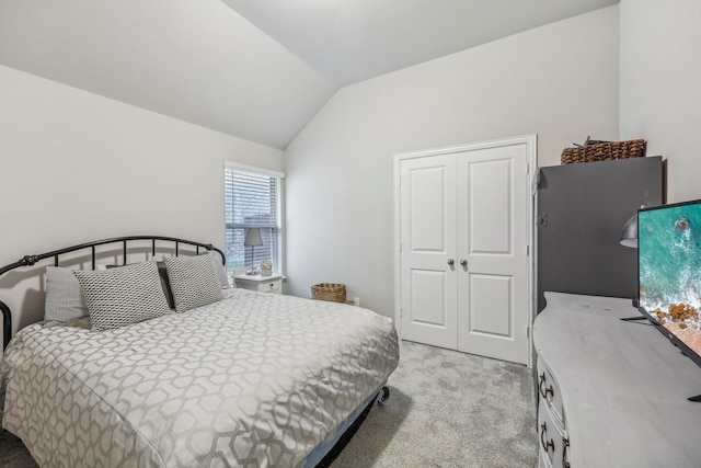 carpeted bedroom with a closet and lofted ceiling