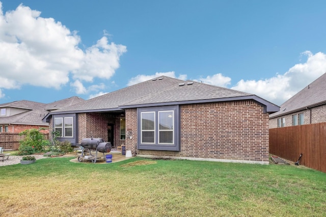 back of house with a lawn and a patio