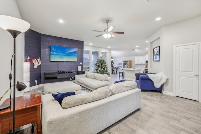 living room featuring light hardwood / wood-style floors and ceiling fan