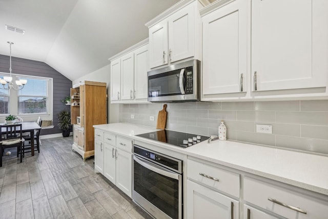 kitchen featuring white cabinetry, light hardwood / wood-style flooring, stainless steel appliances, and vaulted ceiling