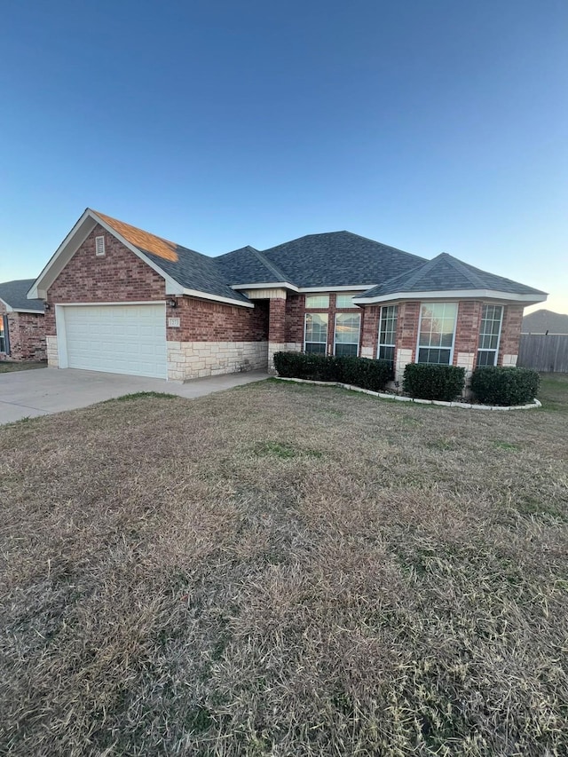 ranch-style house with a garage and a front lawn