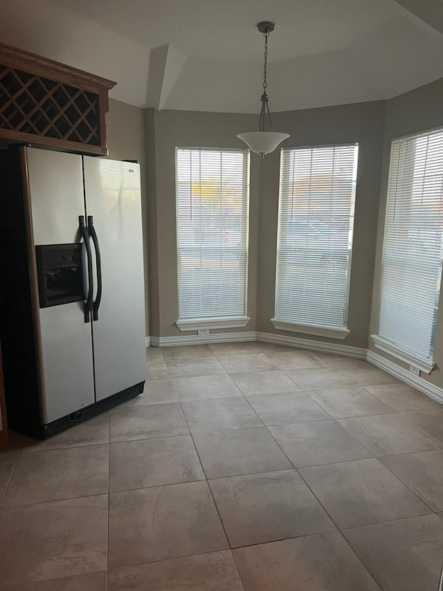 unfurnished dining area with a healthy amount of sunlight and light tile patterned flooring