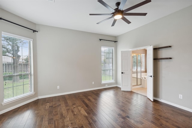 empty room featuring ceiling fan, a healthy amount of sunlight, and dark hardwood / wood-style flooring