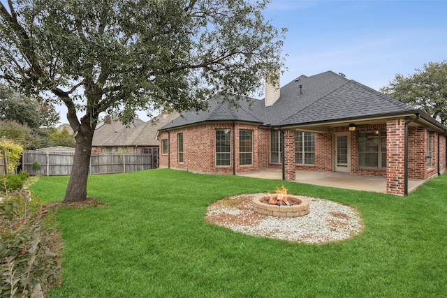 rear view of property featuring a yard, ceiling fan, and a patio area