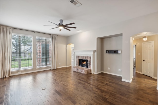 unfurnished living room featuring a fireplace, dark hardwood / wood-style floors, and ceiling fan