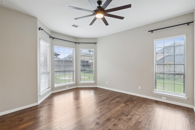 empty room featuring ceiling fan, dark hardwood / wood-style flooring, and a wealth of natural light