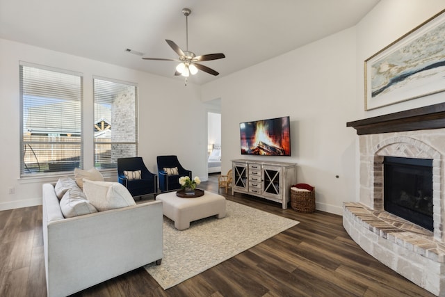 living room featuring a brick fireplace, dark hardwood / wood-style floors, and ceiling fan