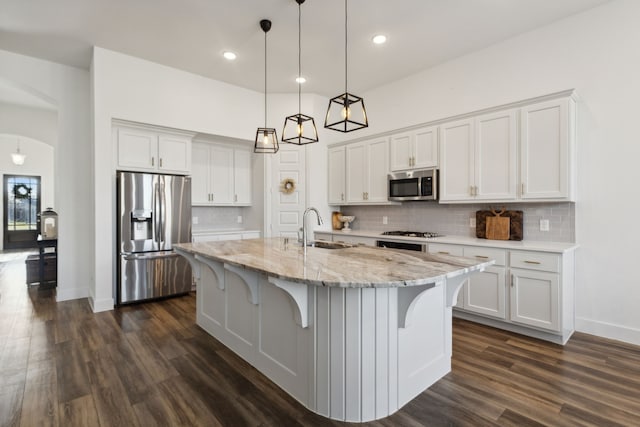 kitchen with a kitchen island with sink, sink, white cabinetry, and stainless steel appliances