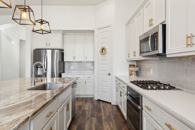 kitchen with stainless steel appliances, white cabinetry, and sink