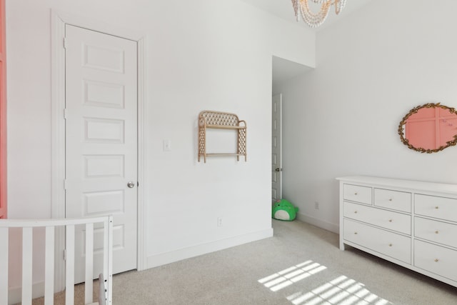 unfurnished bedroom featuring an inviting chandelier and light colored carpet