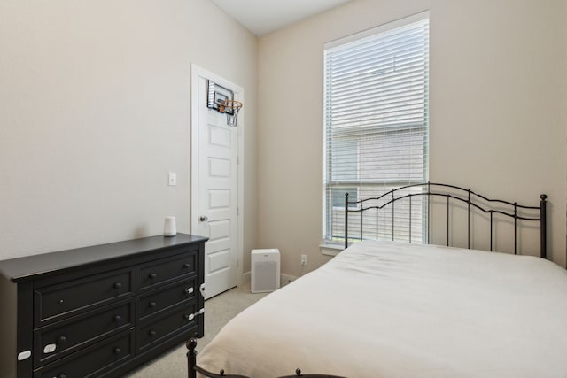 bedroom with multiple windows and light carpet