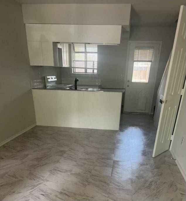 kitchen with stainless steel stove and white cabinetry