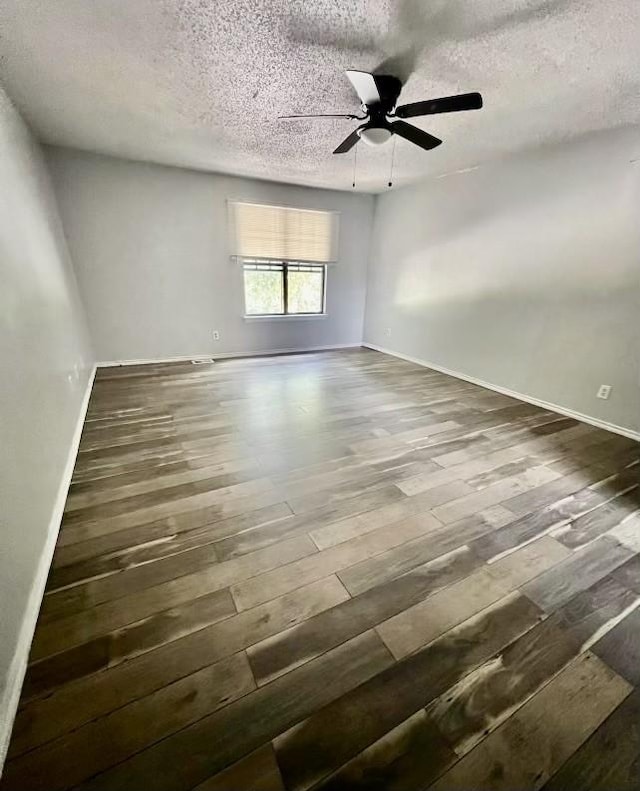 empty room featuring a textured ceiling, dark hardwood / wood-style flooring, and ceiling fan