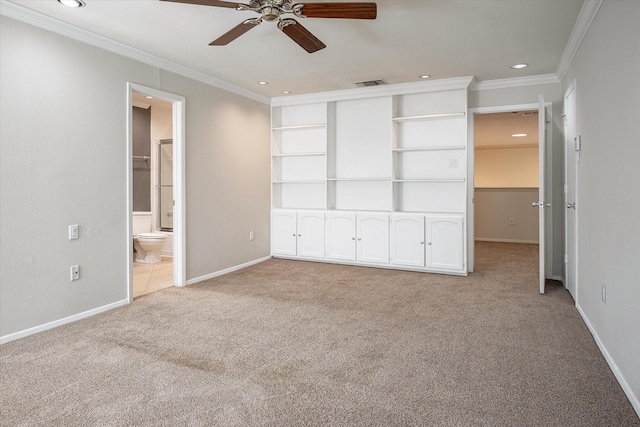 unfurnished bedroom with light carpet, a walk in closet, ceiling fan, and ornamental molding