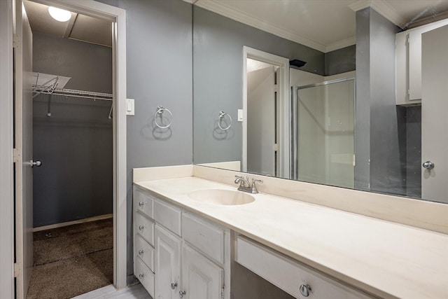 bathroom featuring vanity, a shower with door, and crown molding