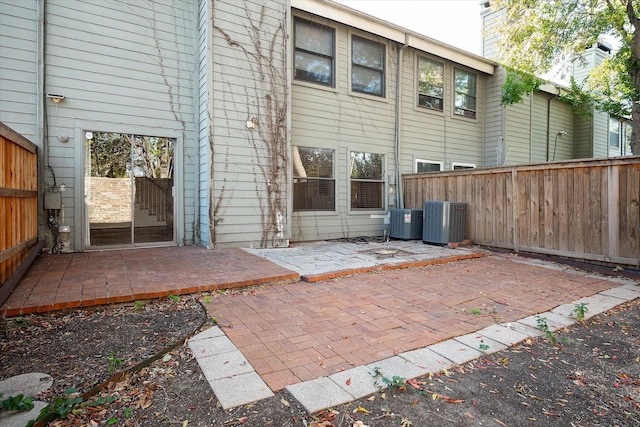 rear view of property featuring central AC unit and a patio area