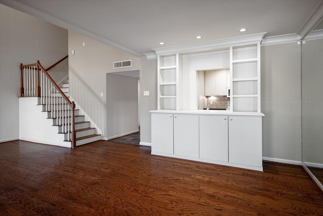 unfurnished living room featuring dark hardwood / wood-style floors and crown molding