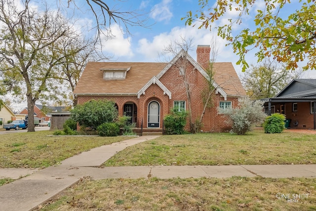 english style home featuring a front yard