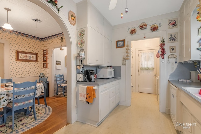 kitchen with hanging light fixtures, white cabinets, and light wood-type flooring