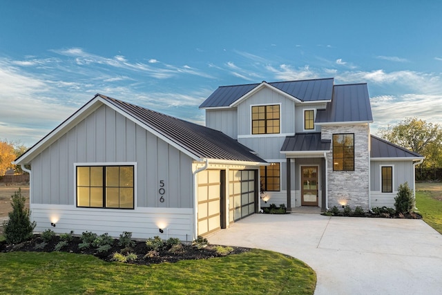 modern farmhouse style home with a front lawn and a garage