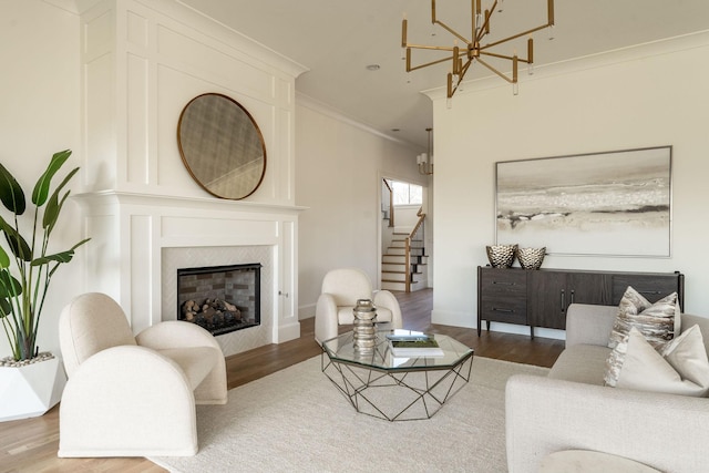 living room featuring a premium fireplace, wood-type flooring, and crown molding