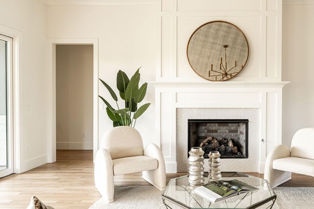 living area featuring a tile fireplace and light hardwood / wood-style flooring