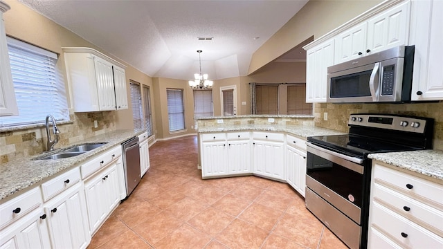 kitchen with white cabinetry, sink, hanging light fixtures, stainless steel appliances, and a chandelier