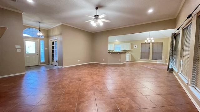 tiled entrance foyer with ceiling fan with notable chandelier, a barn door, ornamental molding, and a textured ceiling