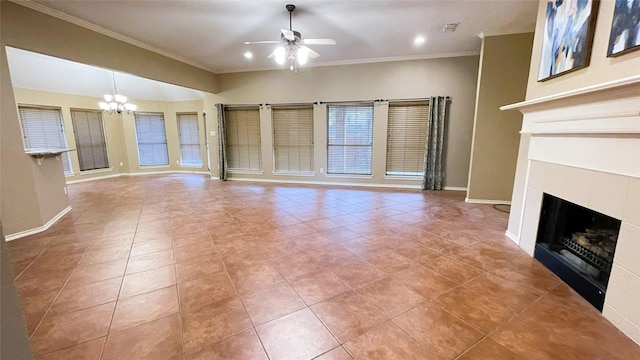 unfurnished living room featuring ceiling fan with notable chandelier, ornamental molding, light tile patterned floors, and a tiled fireplace