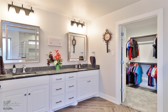 bathroom featuring hardwood / wood-style flooring, vanity, and a shower with door