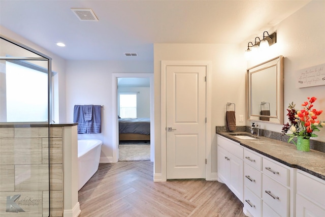 bathroom featuring a bathtub, vanity, and parquet flooring