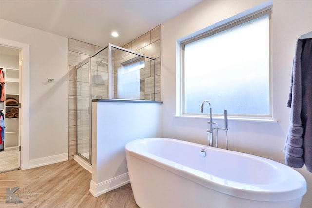 bathroom with plus walk in shower and hardwood / wood-style flooring