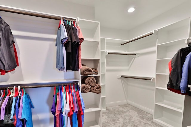 walk in closet featuring light carpet