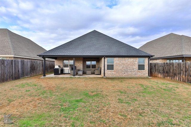 rear view of house featuring a lawn and a patio