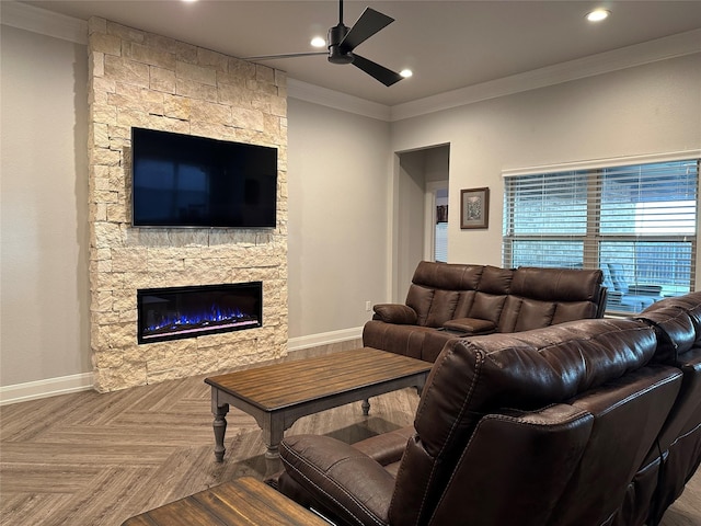 living room with parquet floors, a stone fireplace, ceiling fan, and crown molding