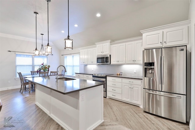 kitchen featuring appliances with stainless steel finishes, decorative light fixtures, sink, and white cabinets