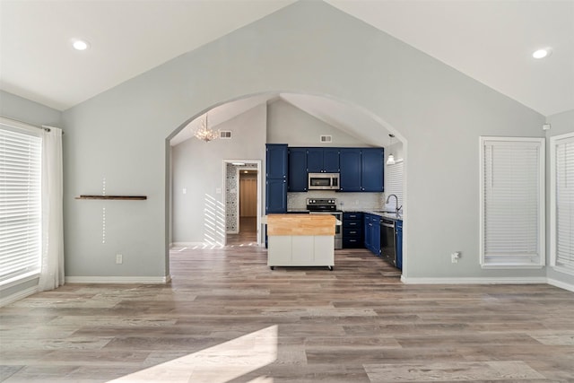 kitchen with wood counters, sink, light hardwood / wood-style floors, stainless steel appliances, and blue cabinetry