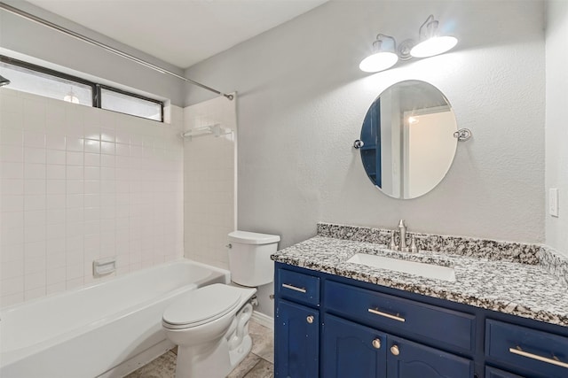 full bathroom featuring vanity, tiled shower / bath combo, and toilet