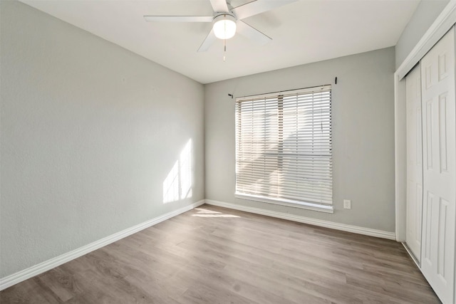 unfurnished bedroom with a closet, ceiling fan, and light wood-type flooring