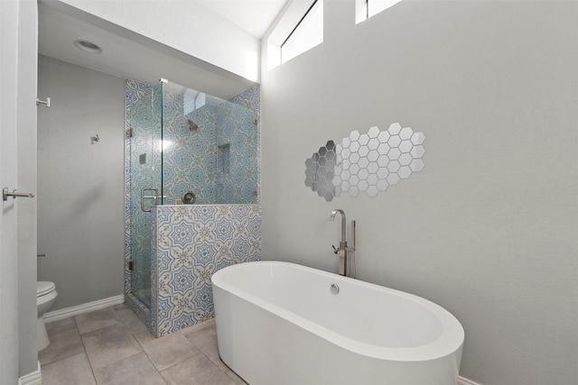 bathroom featuring tile patterned flooring, toilet, and separate shower and tub