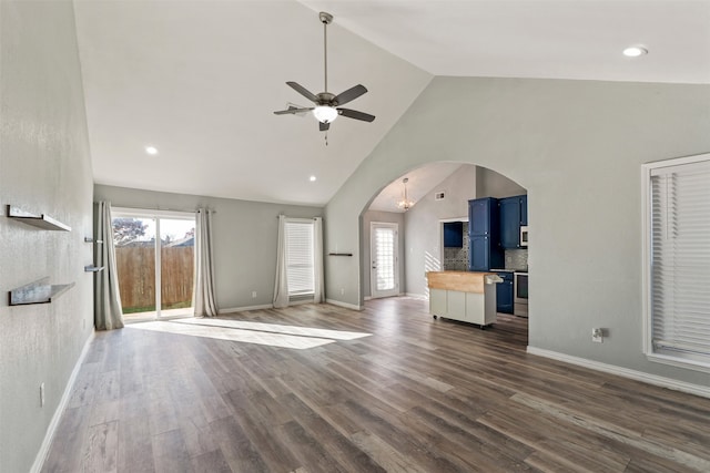 unfurnished living room with dark wood-type flooring, ceiling fan, and high vaulted ceiling